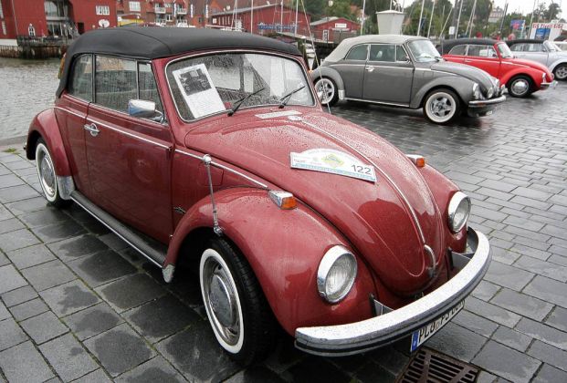 Ein gepflegtes älteres Volkswagen Käfer-Cabriolet mit Weisswandreifen vor zwei Käfer 1303 Cabriolets - Museumshafen Eckernförde