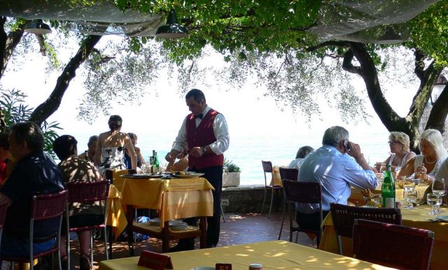 Gardasee-Rundfahrt - Sirmione am Gardasee, schlemmen in einem Gartenrestaurant am Wasser, direkt neben der Scaligerburg
