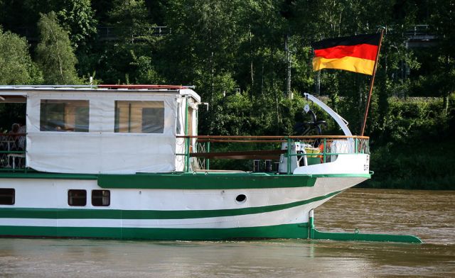 Das Heck des Personendampfers Pirna mit der Nationalflagge vor Bad Schandau 