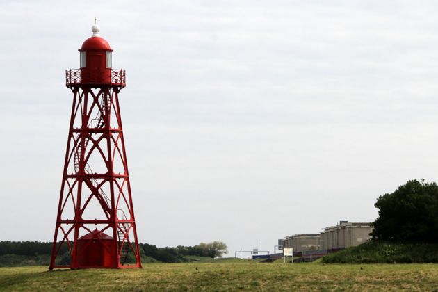 Der kleine 1885 fertiggestellte gusseiserne Hafenleuchtturm und die Stevin-Schleuse am Abschlussdeich des Ijsselmeeres bei Den Oever Der kleine 1885 fertiggestellte gusseiserne Hafenleuchtturm und die Stevin-Schleuse am Abschlussdeich des Ijsselmeeres bei Den Oever