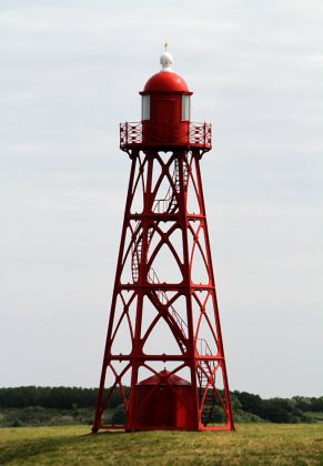 Der kleine 1885 fertiggestellte gusseiserne Hafenleuchtturm und die Stevin-Schleuse am Abschlussdeich des Ijsselmeeres bei Den Oever Der kleine 1885 fertiggestellte gusseiserne Hafenleuchtturm und die Stevin-Schleuse am Abschlussdeich des Ijsselmeeres bei Den Oever