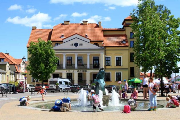 Mikolaiki, Mazury - Nikolaiken, Masuren - der Marktplatz mit historischem Rathaus und dem Stinthengst-Brunnen