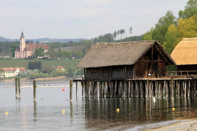 Die Pfahlbauten am Bodensee mit der Wallfahrtskirche Birnau im Hintergrund Die Pfahlbauten am Bodensee mit der Wallfahrtskirche Birnau im Hintergrund