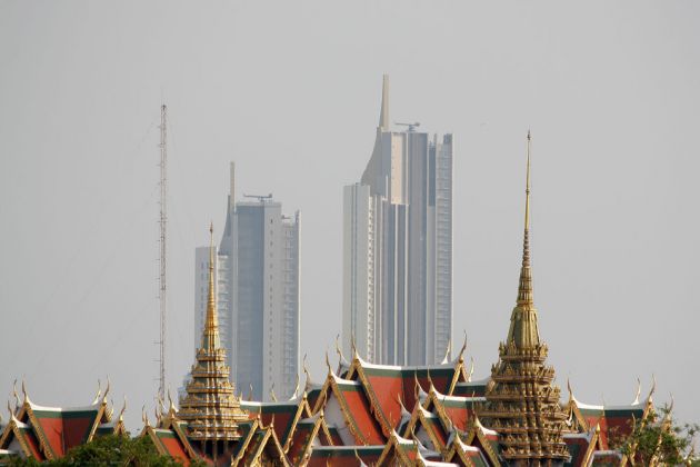 Das Bangkok der Gegensätze - die vergoldeten Dächer des Königspalastes und riesige Wolkenkratzer im Background