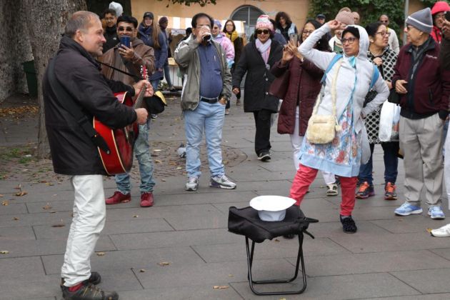 Ein Strassenmusiker begeistert indische Touristen auf der Kohtuotsa Aussichtsplattform - Domberg in Tallinn Ein Strassenmusiker begeistert indische Touristen auf der Kohtuotsa Aussichtsplattform - Domberg in Tallinn