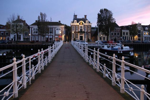 Der Radhuissteeg über den Noorderhaven mit dem historischen Rathaus von Harlingen zur Blauen Stunde