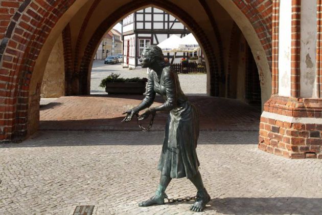 Tangermünde in der Altmark - das Grete-Minde-Denkmal neben der Gerichtslaube des historischen Rathauses Tangermünde in der Altmark - das Grete-Minde-Denkmal neben der Gerichtslaube des historischen Rathauses