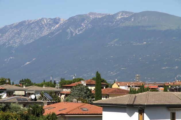 Toscolano-Maderno an der Riviera Bresciana des Gardasees - der Blick über die Dächer der Stadt auf den Monte Baldo Toscolano-Maderno an der Riviera Bresciana des Gardasees - der Blick über die Dächer der Stadt auf den Monte Baldo