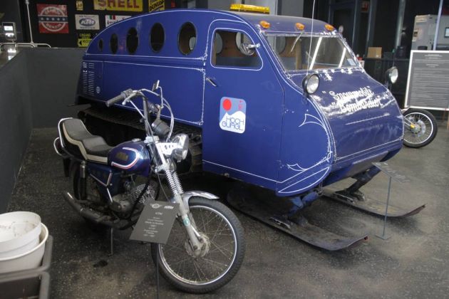 Ein in Kanada eingesetztes Bombardier-Schneefahrzeug 'B-12CS', Baujahr 1947 hinter einem KTM 50 ccm Chopper- Top Mountain Motorcycle Museum Ein in Kanada eingesetztes Bombardier-Schneefahrzeug 'B-12CS', Baujahr 1947 hinter einem KTM 50 ccm Chopper- Top Mountain Motorcycle Museum
